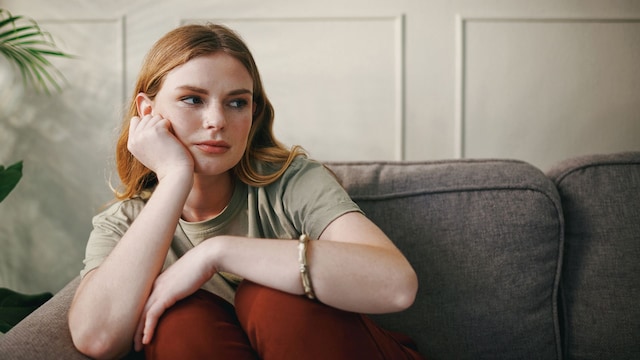 Mujer sentada en el sofá en actitud triste