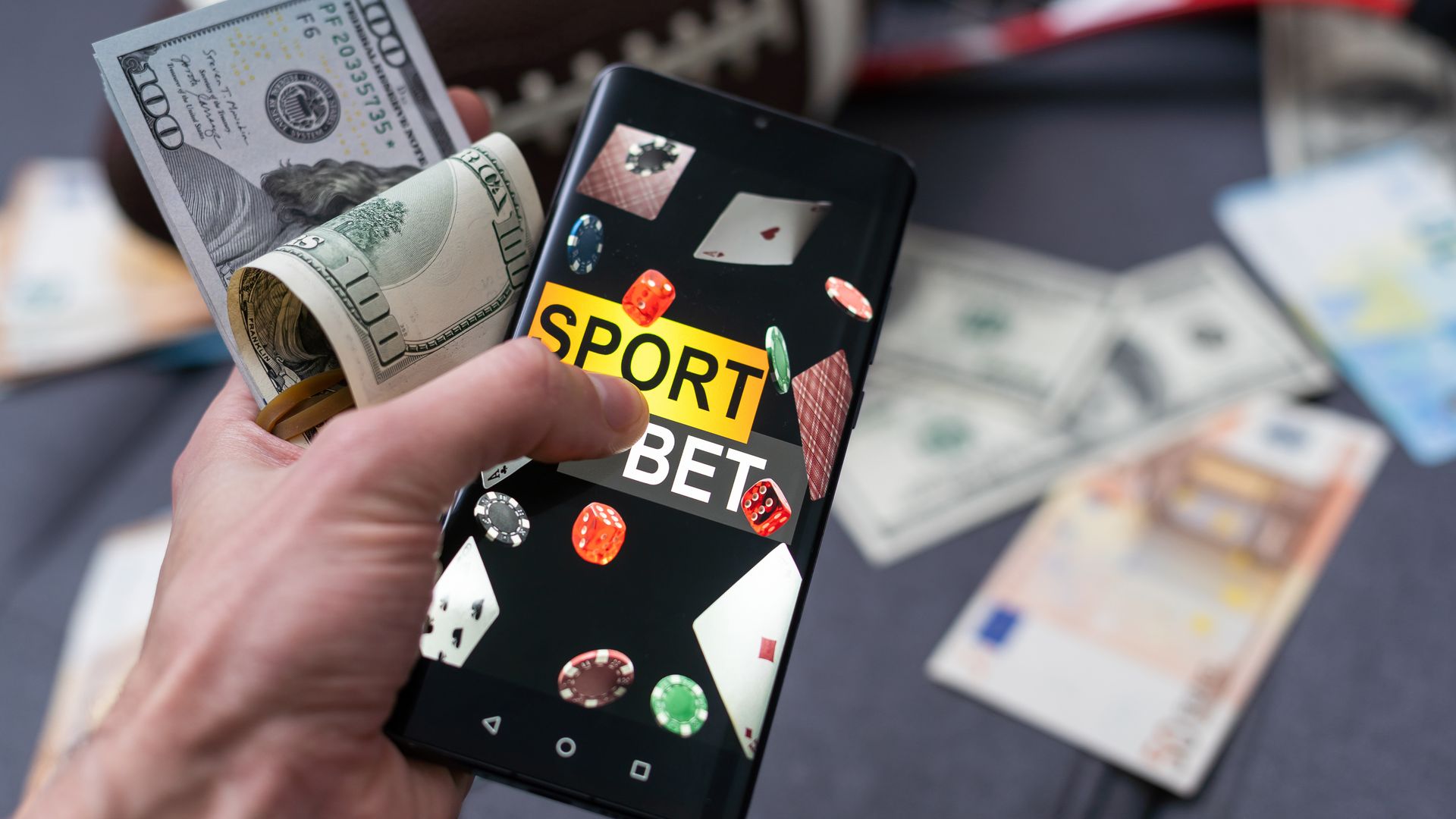 Smartphone con aplicación de apuestas, pelota y billetes. Concepto de deporte y apuestas.