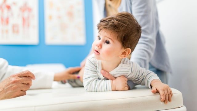 Niño pequeño en la consulta del pediatra junto a su madre