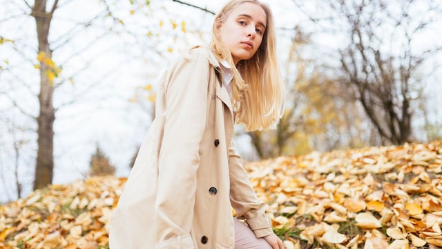 mujer joven mirando a la cámara en un bosque otoñal