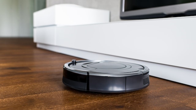 Un robot aspirador sobre un suelo de madera