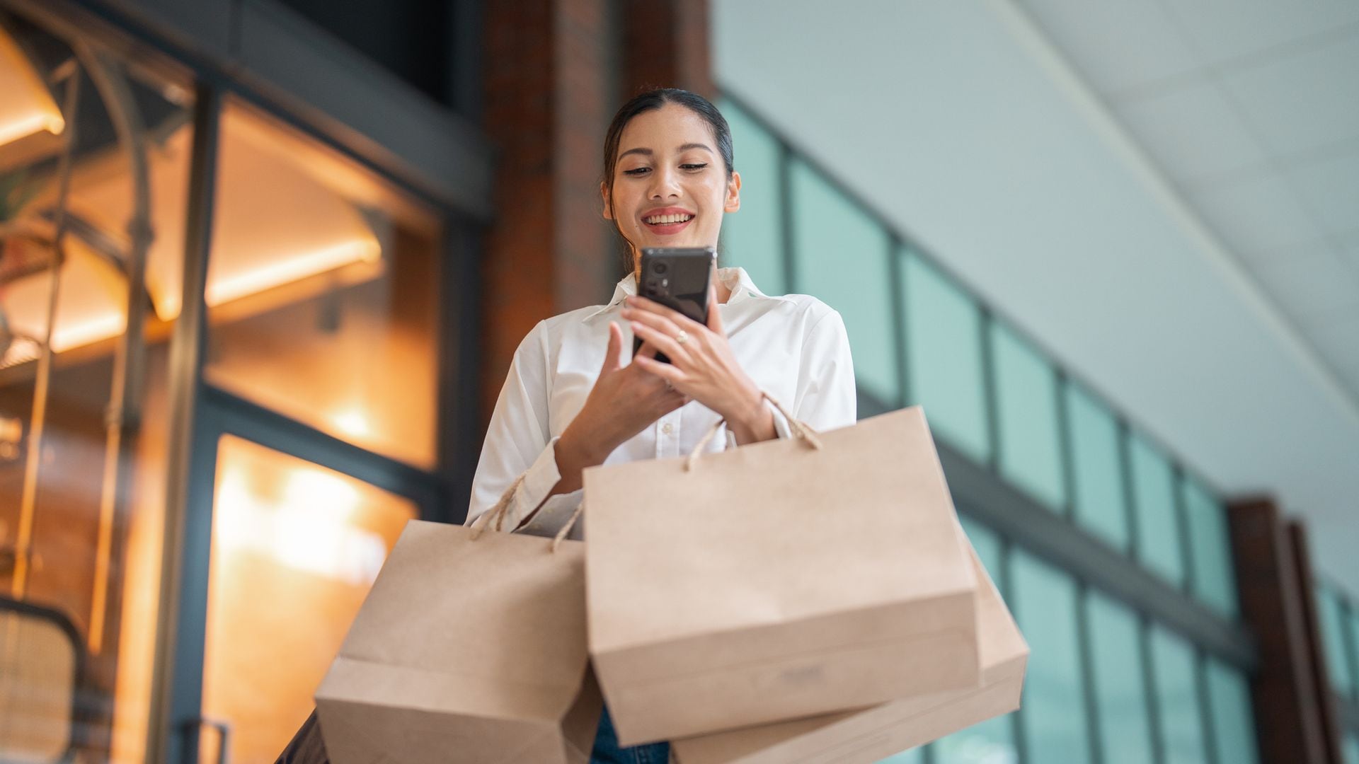 Una chica de compras con su teléfono móvil