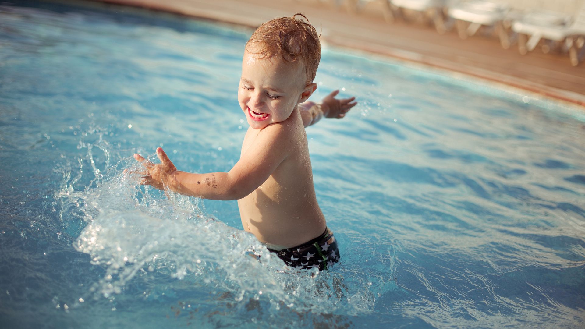 niño jugando en el agua de una piscina