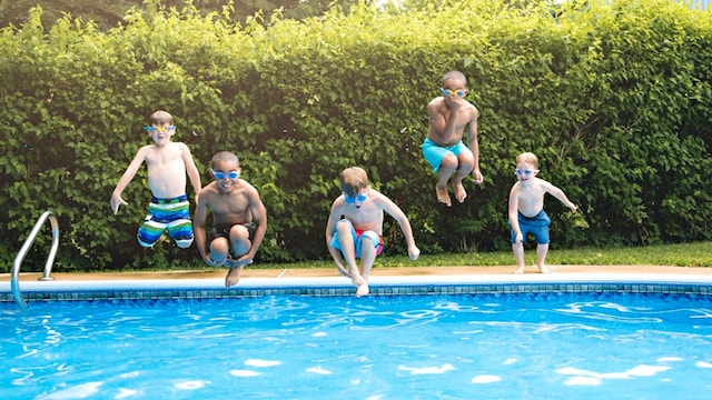ni os jugando en la piscina en verano 