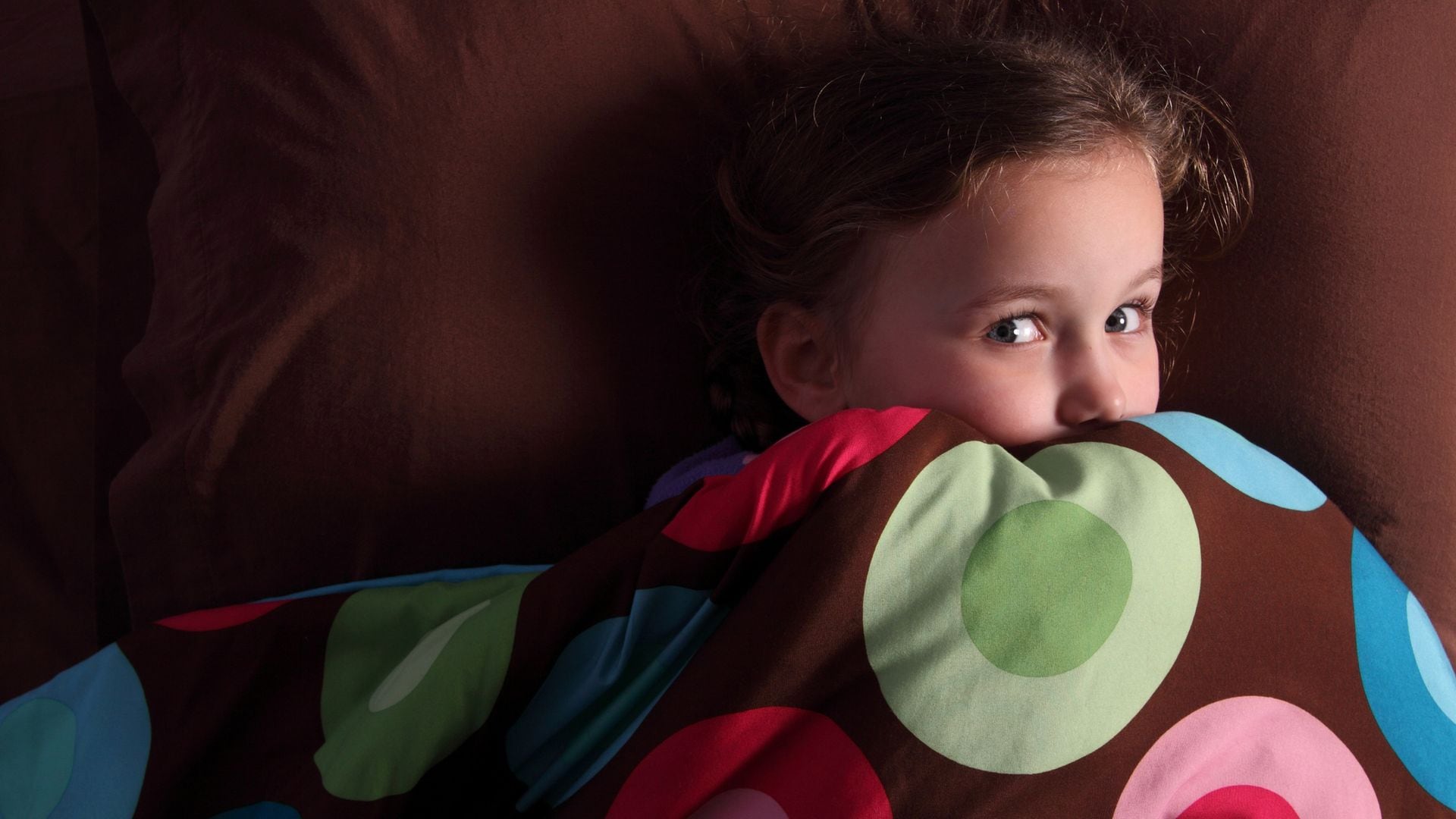 Niña asustada en la cama