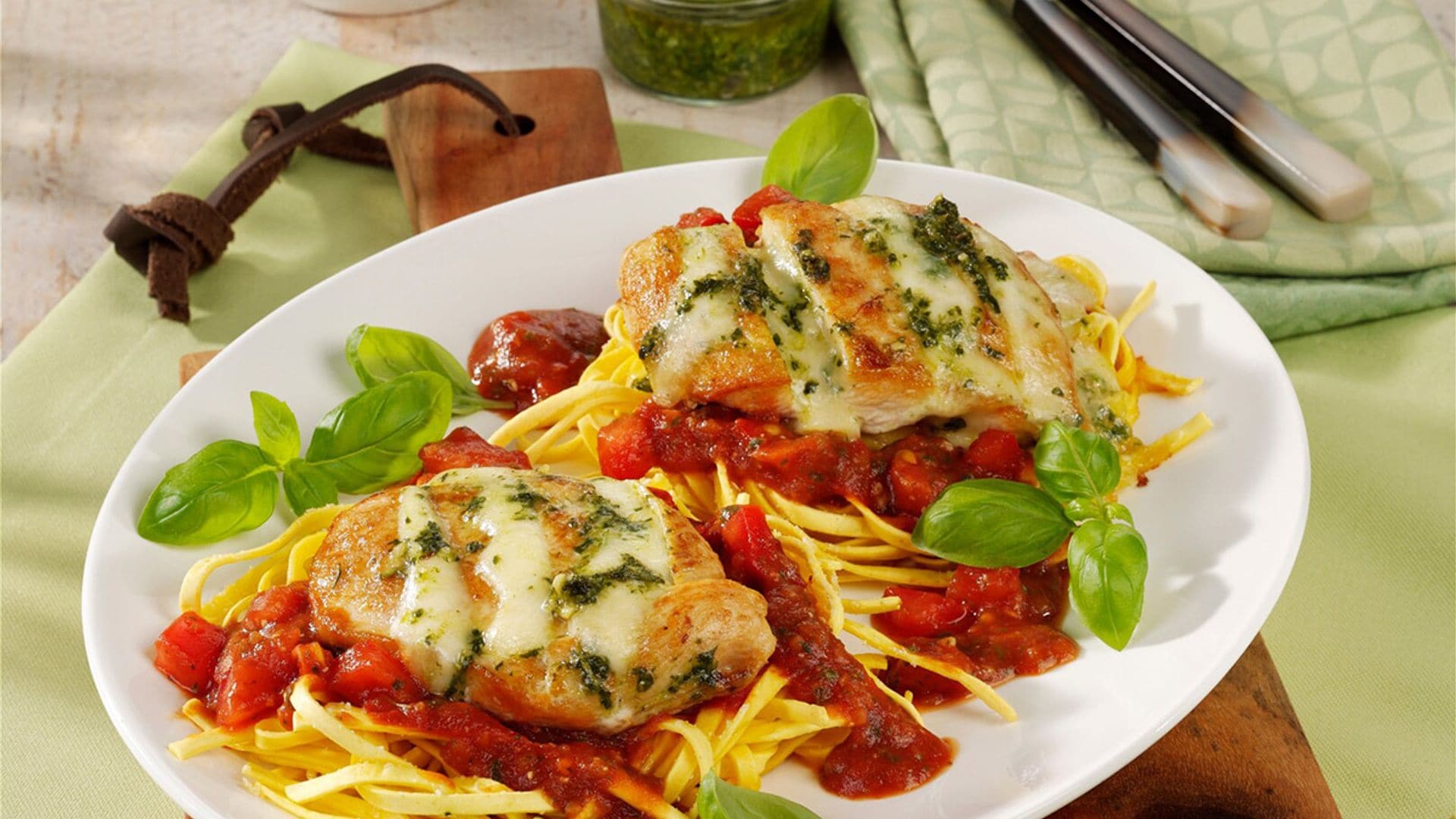 Pechugas de pollo gratinadas con queso y pesto sobre salsa de tomate casera