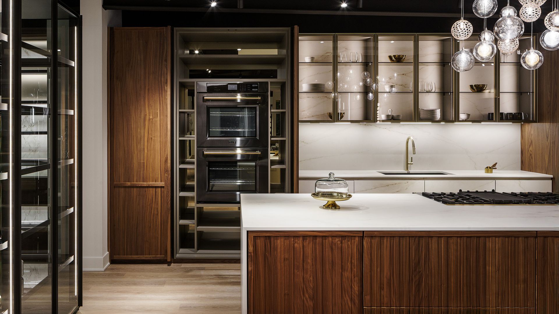 Cocina en madera con vitrinas, lámpara de techo, encimera blanca, electrodomésticos en armario