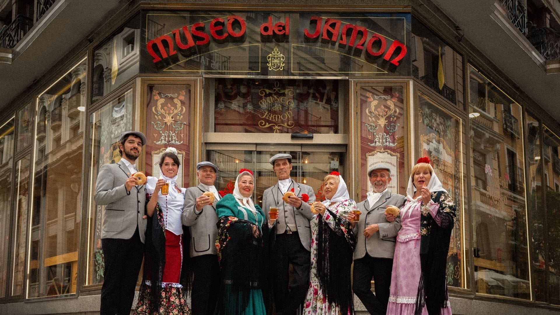 Grupo de chulapos frente al Museo del Jamón en Madrid con rosquillas jamoneras