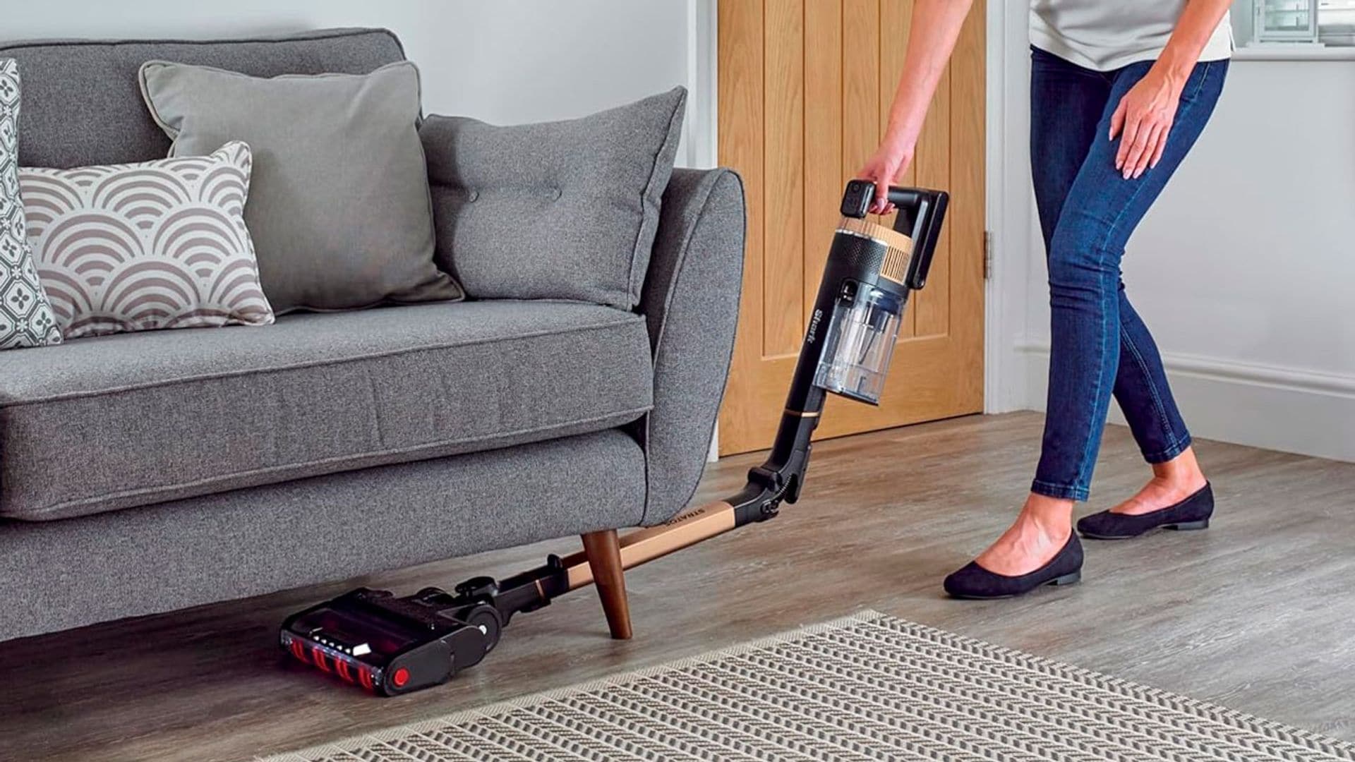 Una mujer pasando la aspiradora sin cable Shark