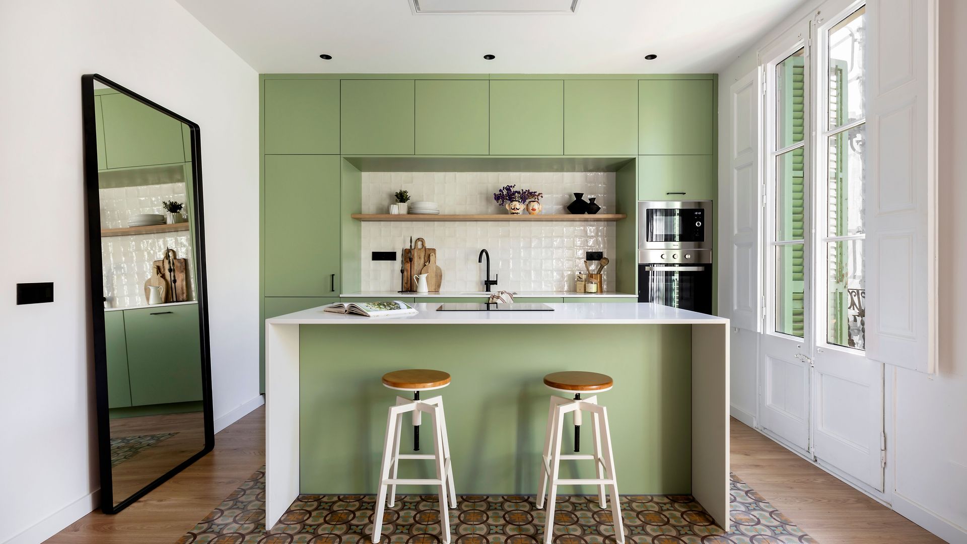 Cocina luminosa con muebles en verde y espejo de pie