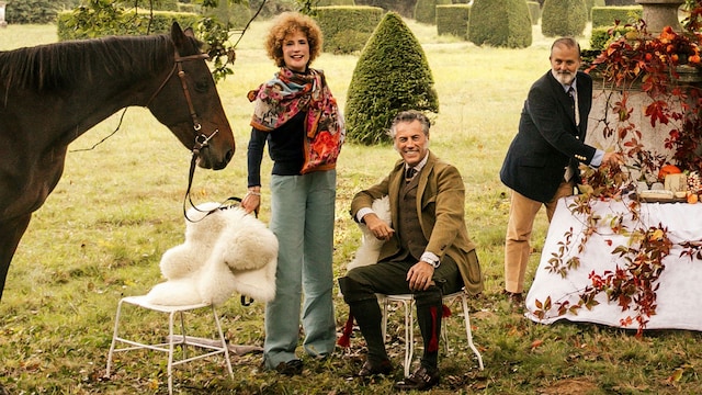 Flore de Brantes posando con sus grandes amigos el artista Ignacio Goitia y Alejandro Muguerza, en el idílico jardín del castillo. Los platos y los cojines están diseñador por Goitia, autor también del fular que lleva la condesa, emulando el dibujo del techo del comedor principal. El coche inglés Break, hecho por Hermès, fue usado originalmente para cazar.