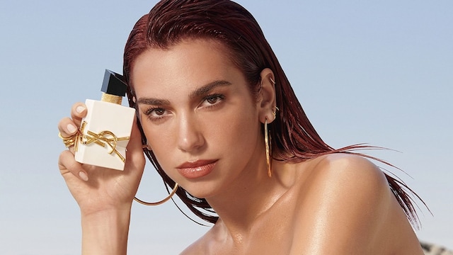Dua Lipa con bañador apoyada sobre una roca con perfume Libre
