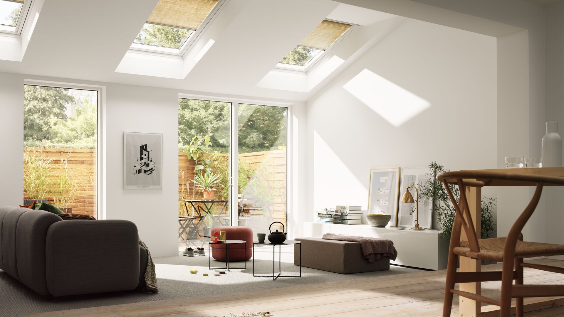 Salón comedor con ventanas de techo Velux, mueble bajo blanco, sofá marrón, butaca, grandes ventanales con salida a un patio