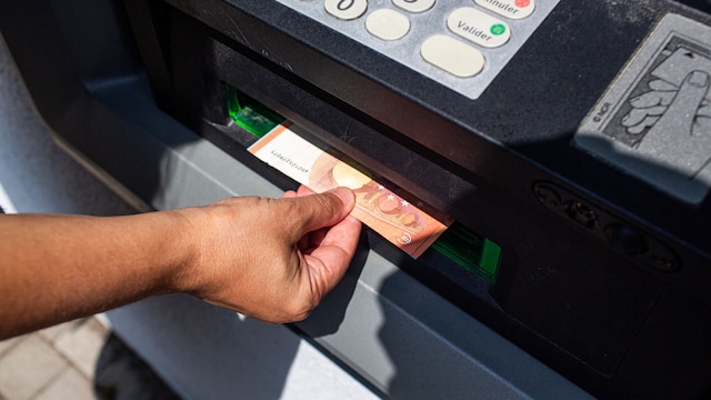 Persona sacando dinero en efectivo de un cajero automático     