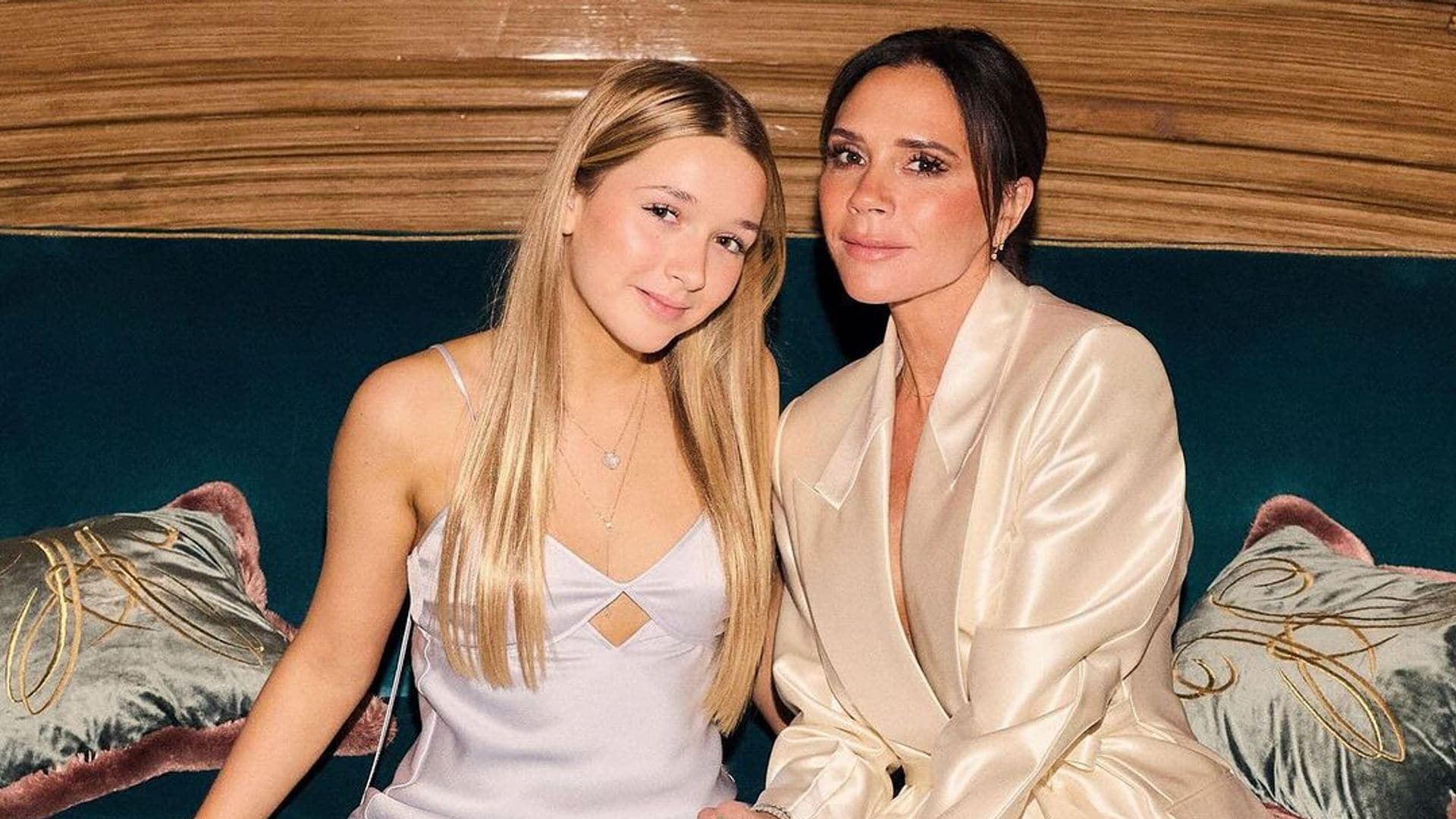 Harper Seven con su madre, Victoria Beckham, posando sentadas con conjuntos satinados