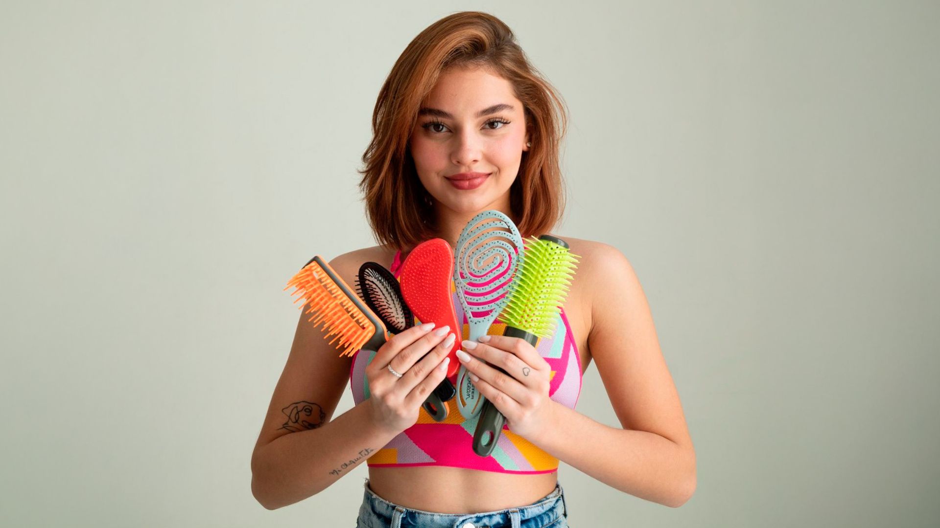 Mujer pelirroja con diferentes cepillos de pelo de Beter en la mano