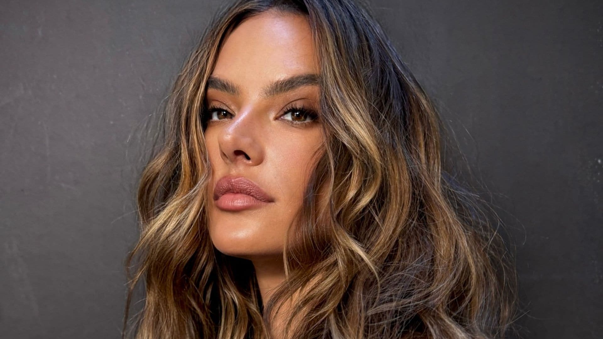 Alessandra Ambrosio con el pelo ondulado y jersey beige