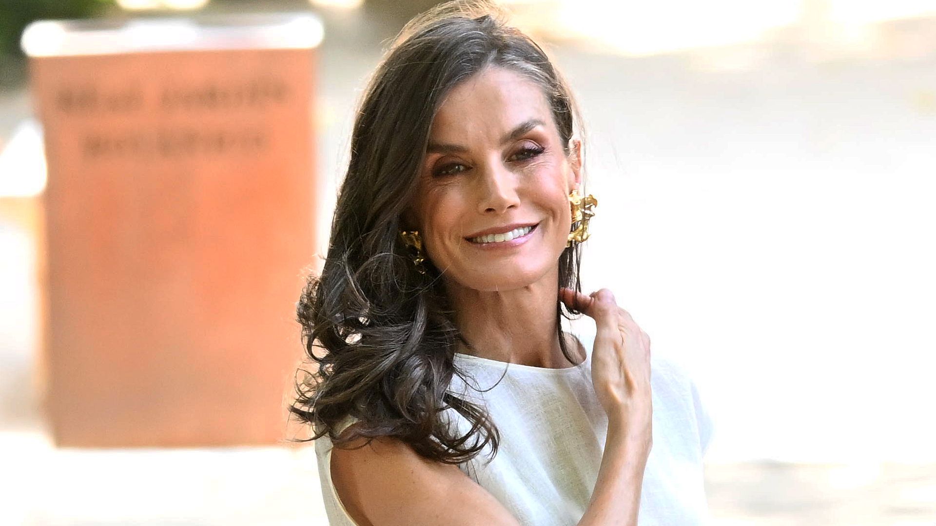 La reina Letizia con vestido blanco, pelo suelto ondulado y maquillaje natural en el Real Jardín Botánico
