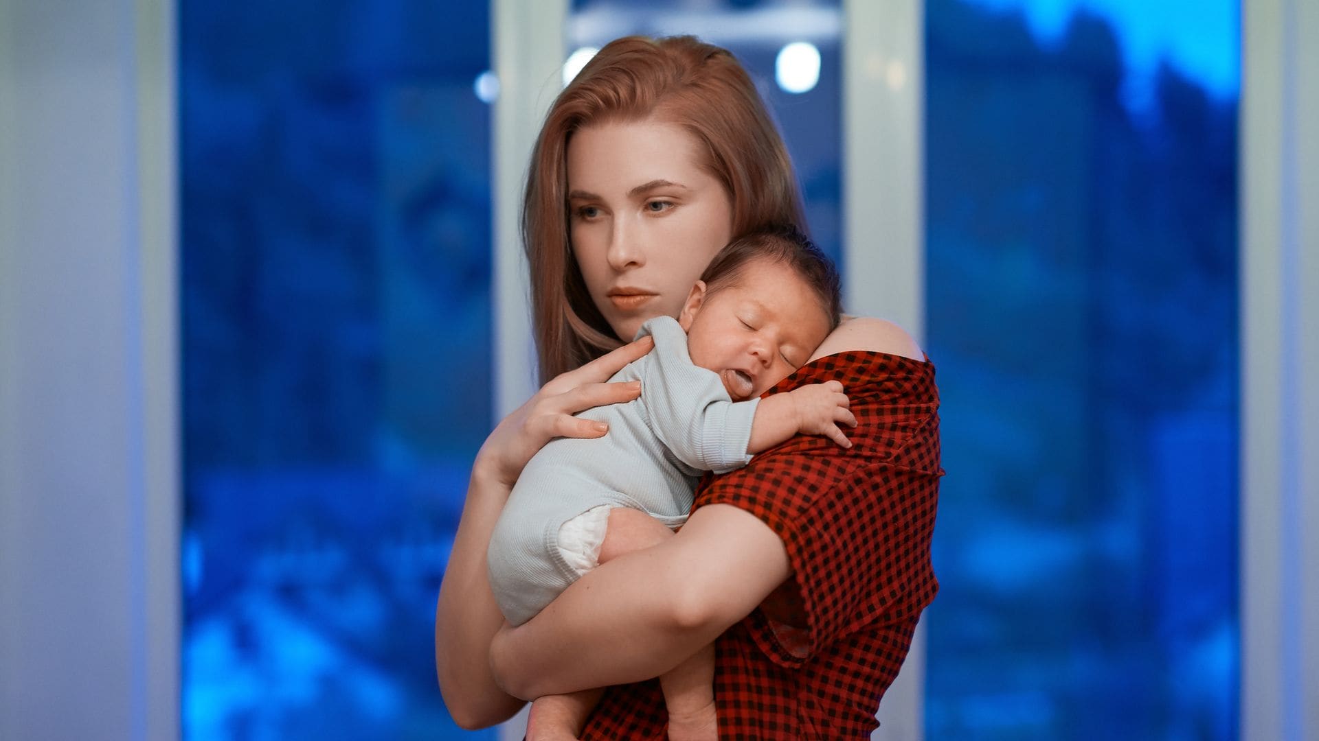 Madre con su bebé en brazos por la noche