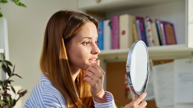 mujer joven mirándose en un espejo 