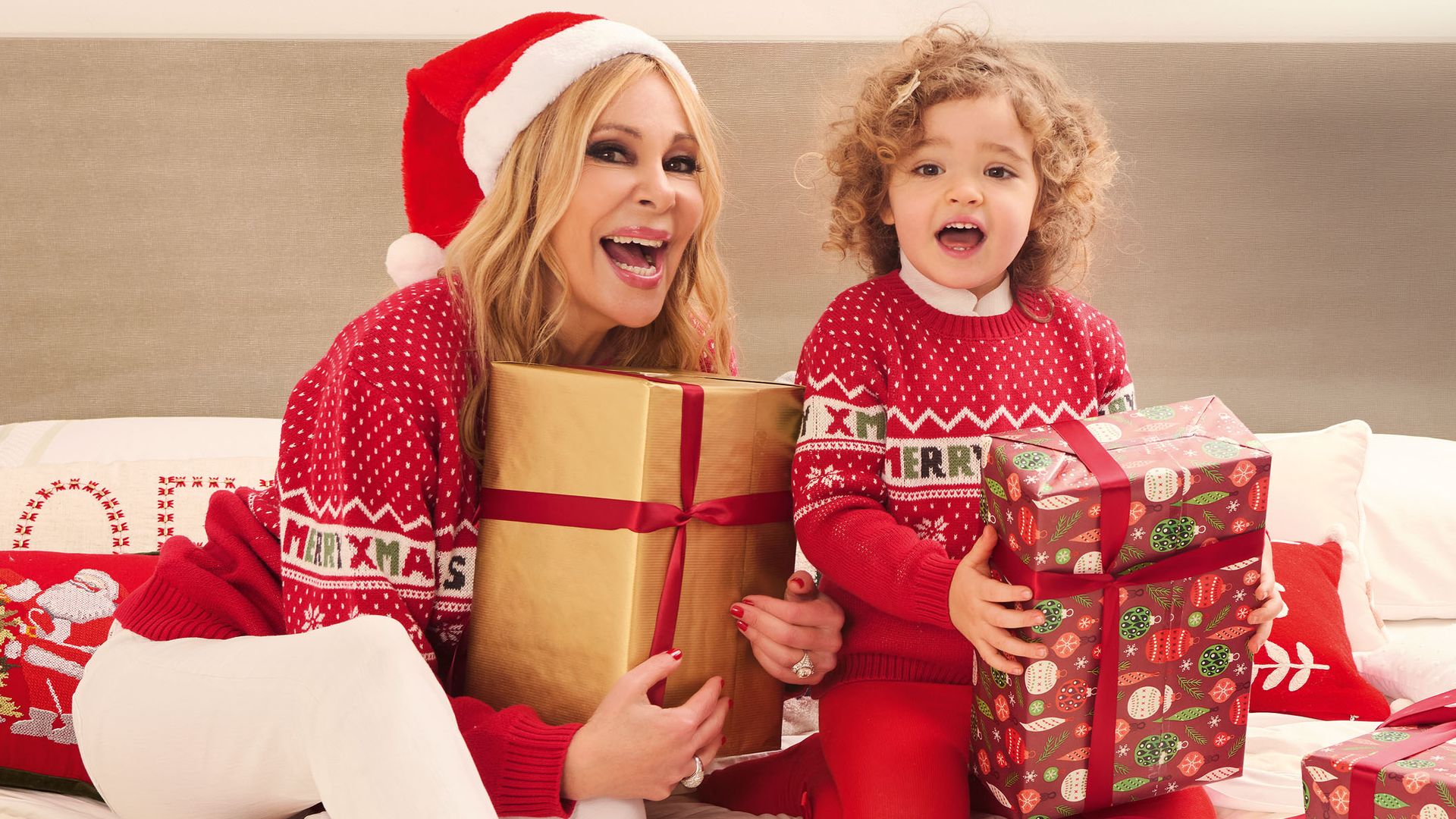 Ana Obregón con un gorro de Papá Noel y Anita, con un montón de regalos en la cama