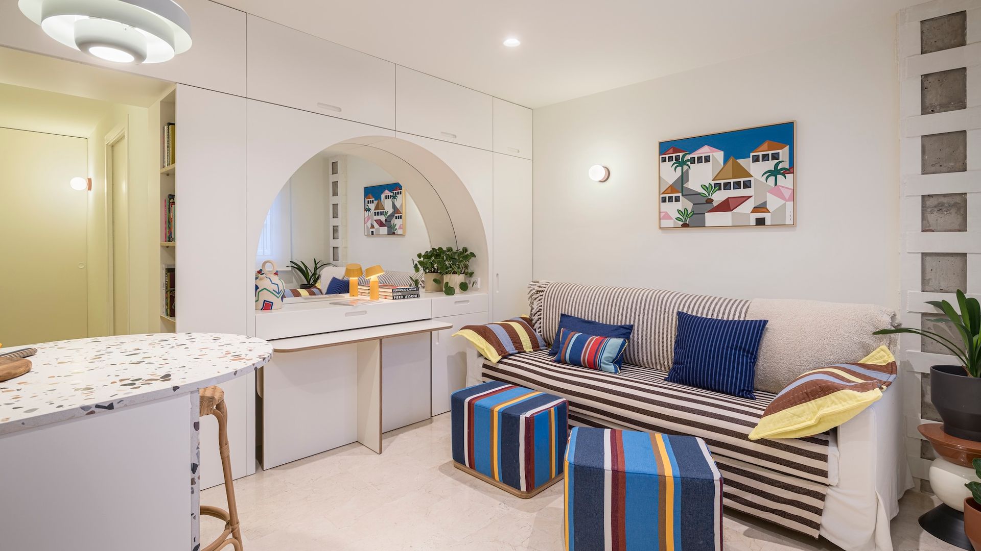 Salón con mueble a medida con espejos para guardar los puffs.  