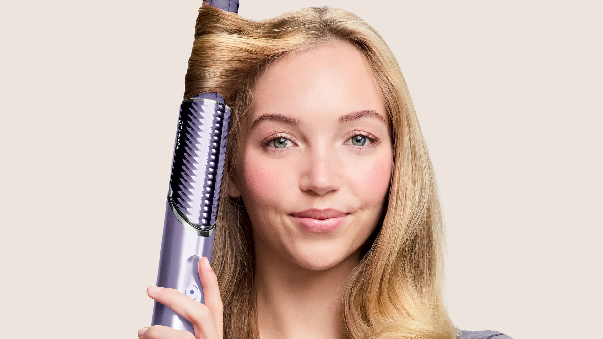 Mujer rubia sonriente usando el FlexStyle IonCurl de Shark en color violeta
