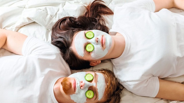 pareja con mascarilla facial de belleza pepinos en los ojos 