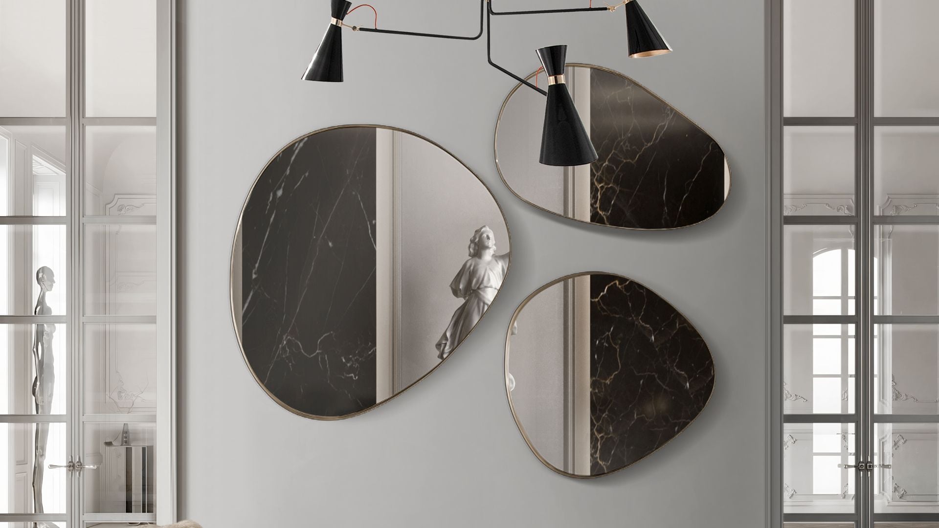Pared decorada con una composición de tres espejos de formas orgánicas