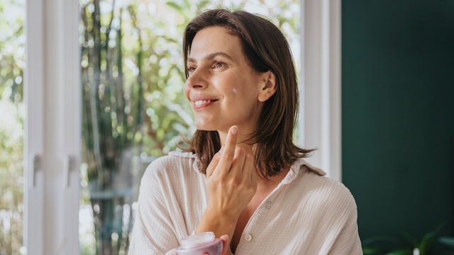 Mujer en la menopausia usando crema facial