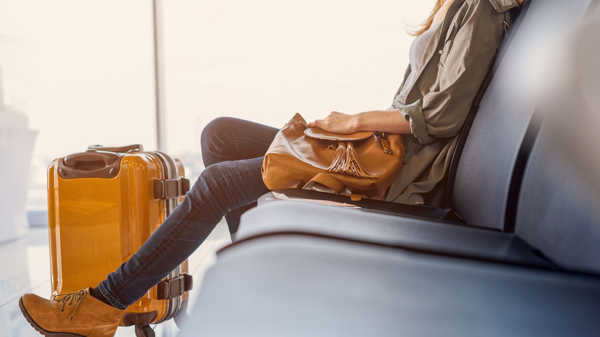 Mujer viajera con maleta esperando en el aeropuerto