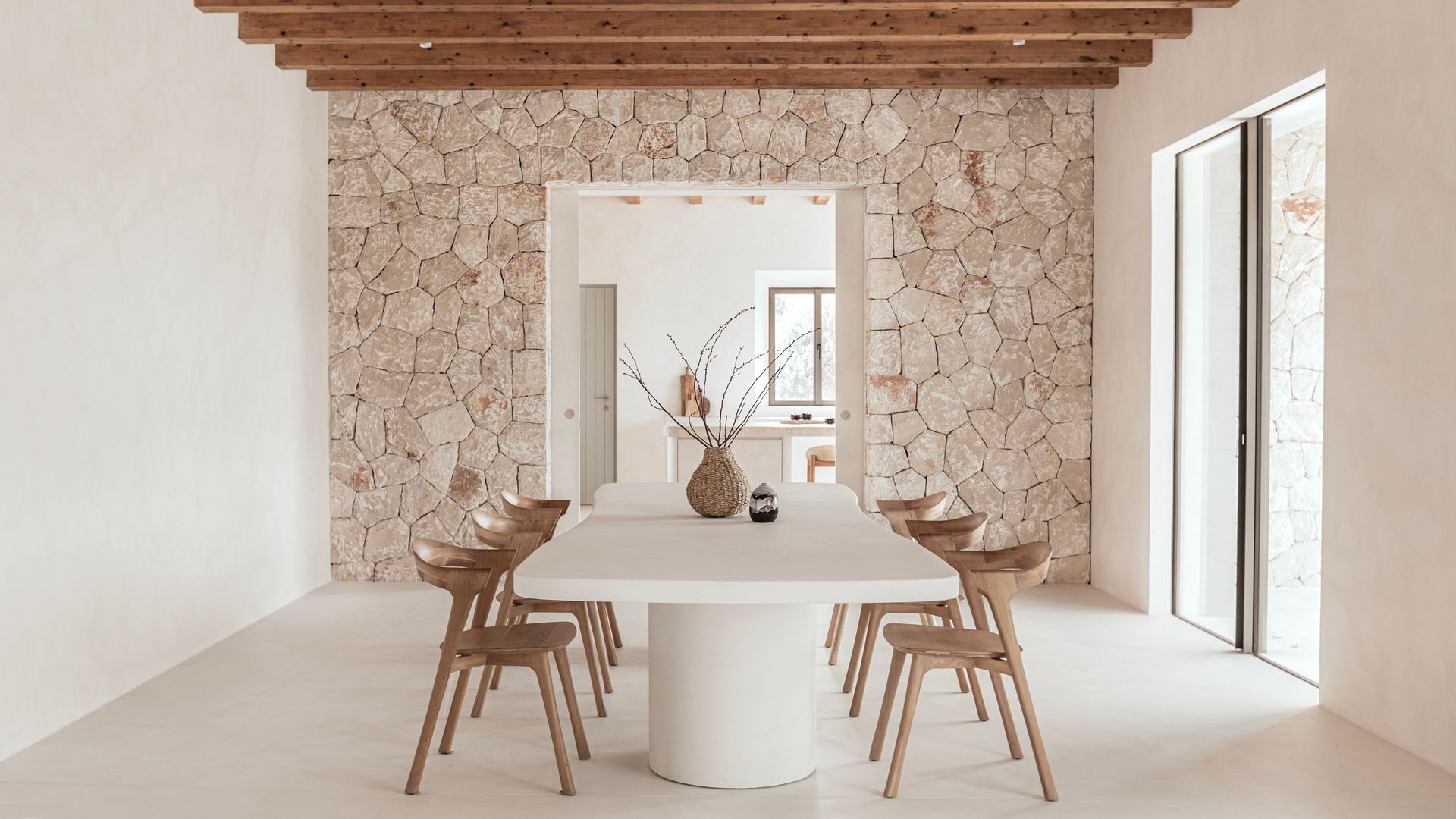 Comedor con paredes de piedra vista y vigas de madera en el techo