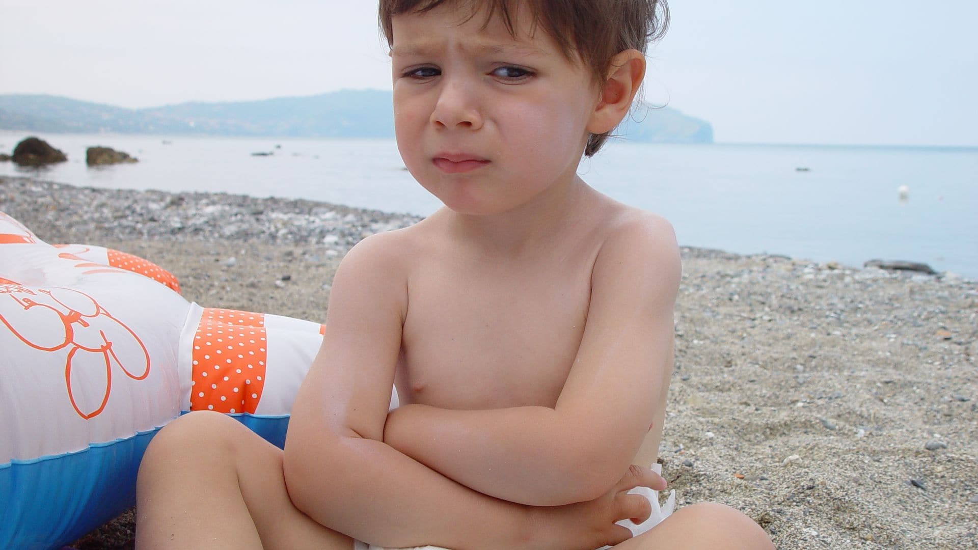 Niño pequeño con gastroenteritis en la playa