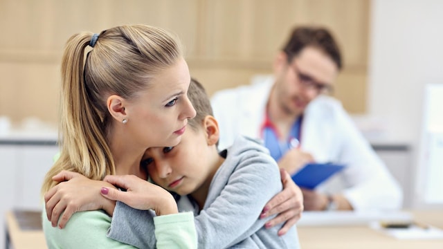 ni o abrazado a su madre en la consulta del pediatra