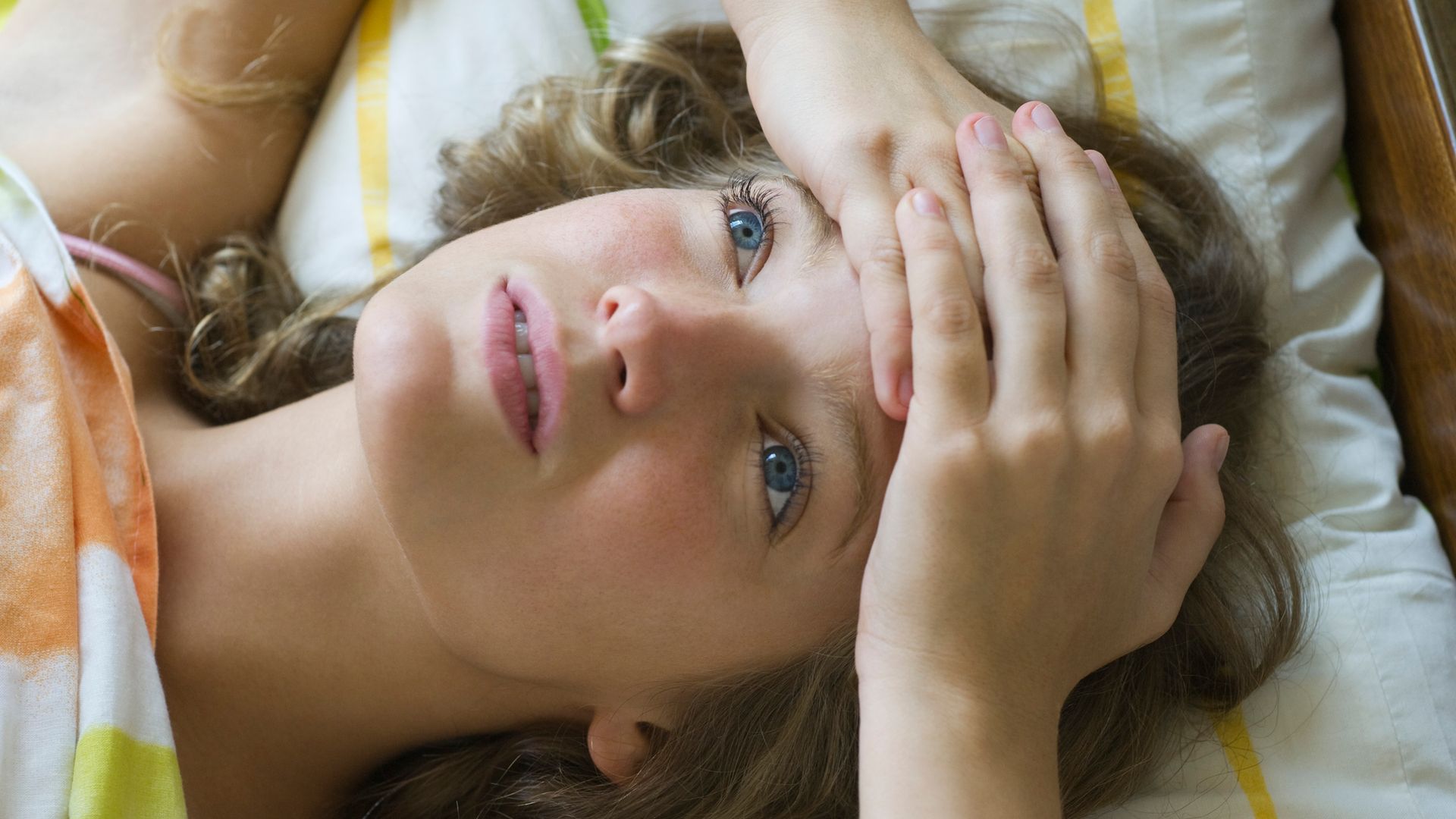 Mujer tumbada en la cama sin poder dormir