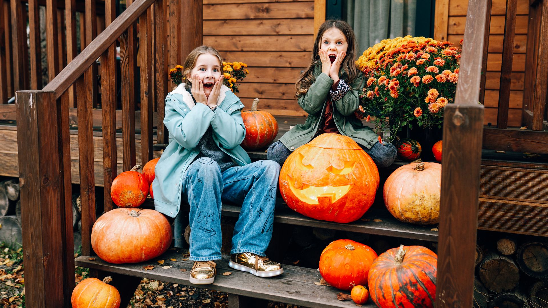 Dos niñas sorprendidas y asustadas, celebrando Halloween, rodeadas de calabazas