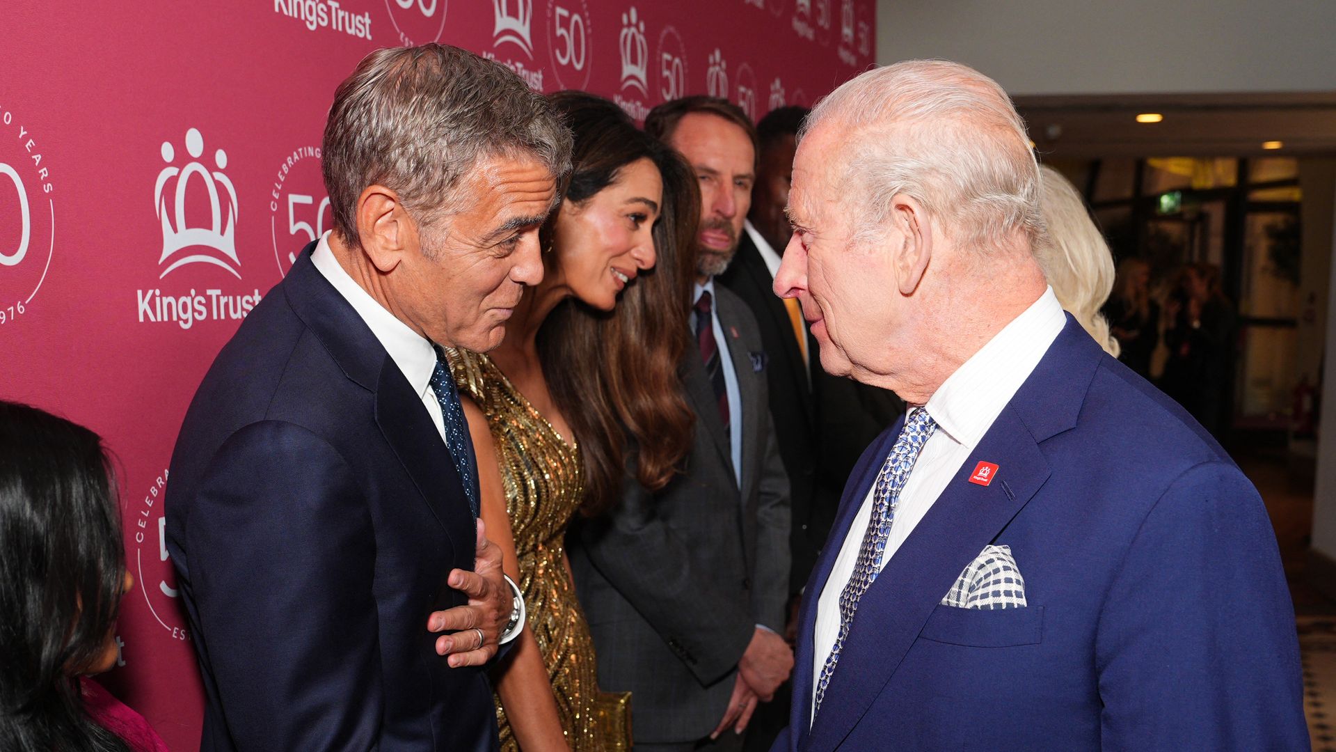 Los reyes Carlos y Camilla saludan a George y Amal Clooney