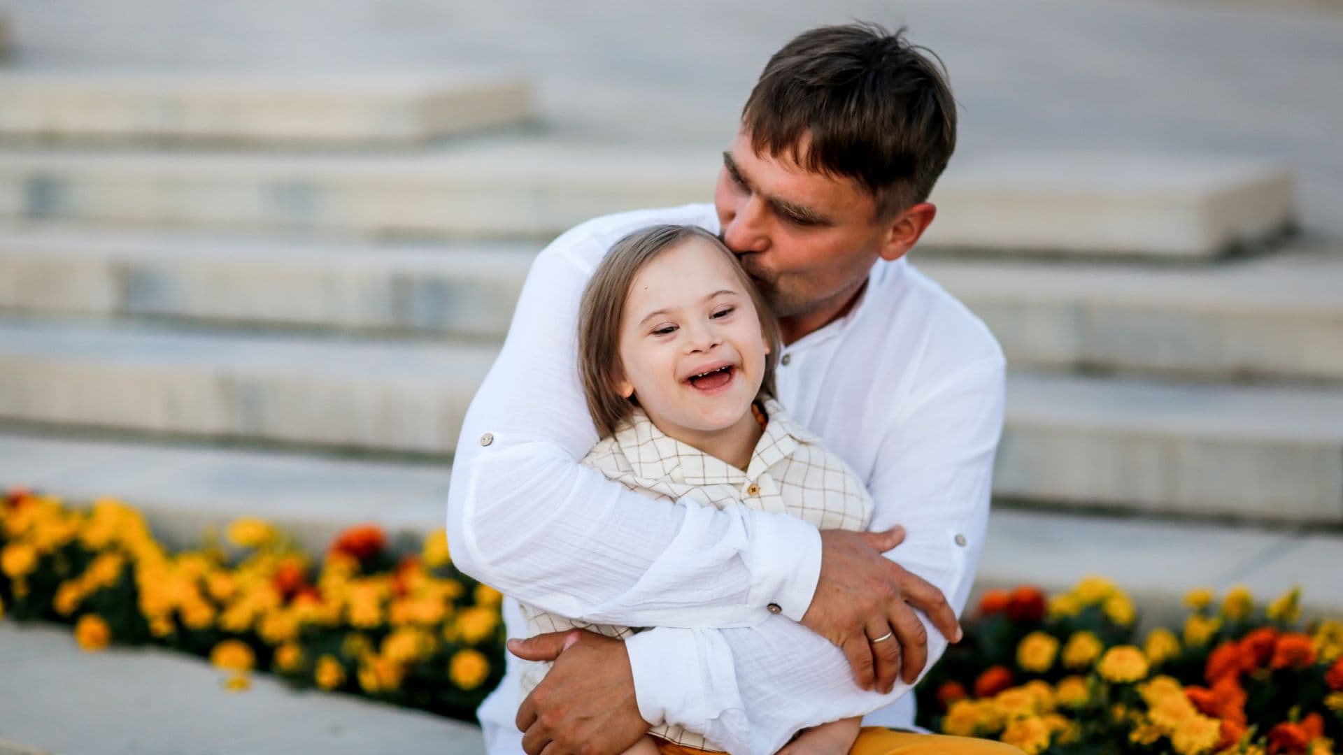 Padre besa y abraza a su hija con síndrome de Down