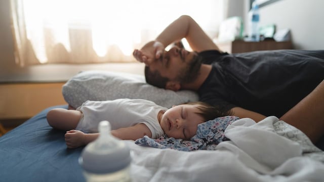 ni o durmiendo con padre cansado en la cama