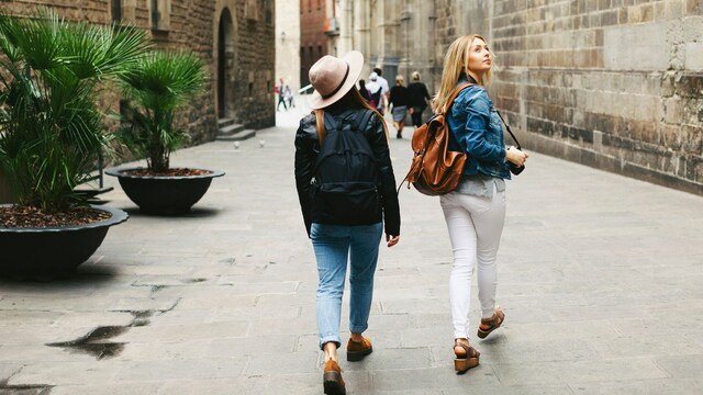 Dos chicas de viaje haciendo turismo por la ciudad de Barcelona en primavera u otoño