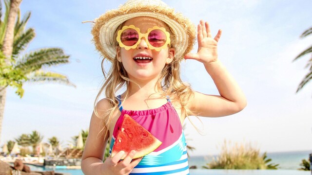 ni a comiendo sand a en verano en la piscina 