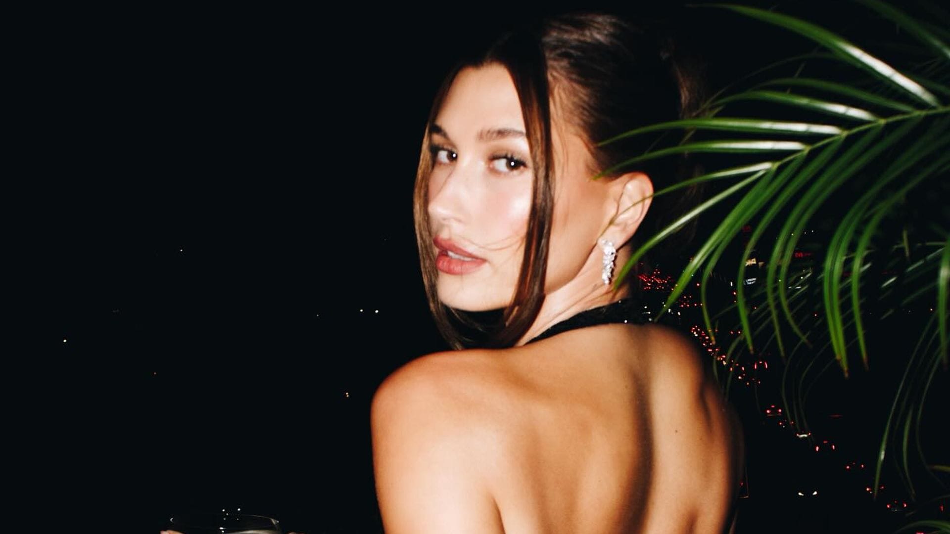 Hailey Bieber con vestido de espalda al aire y moño alto