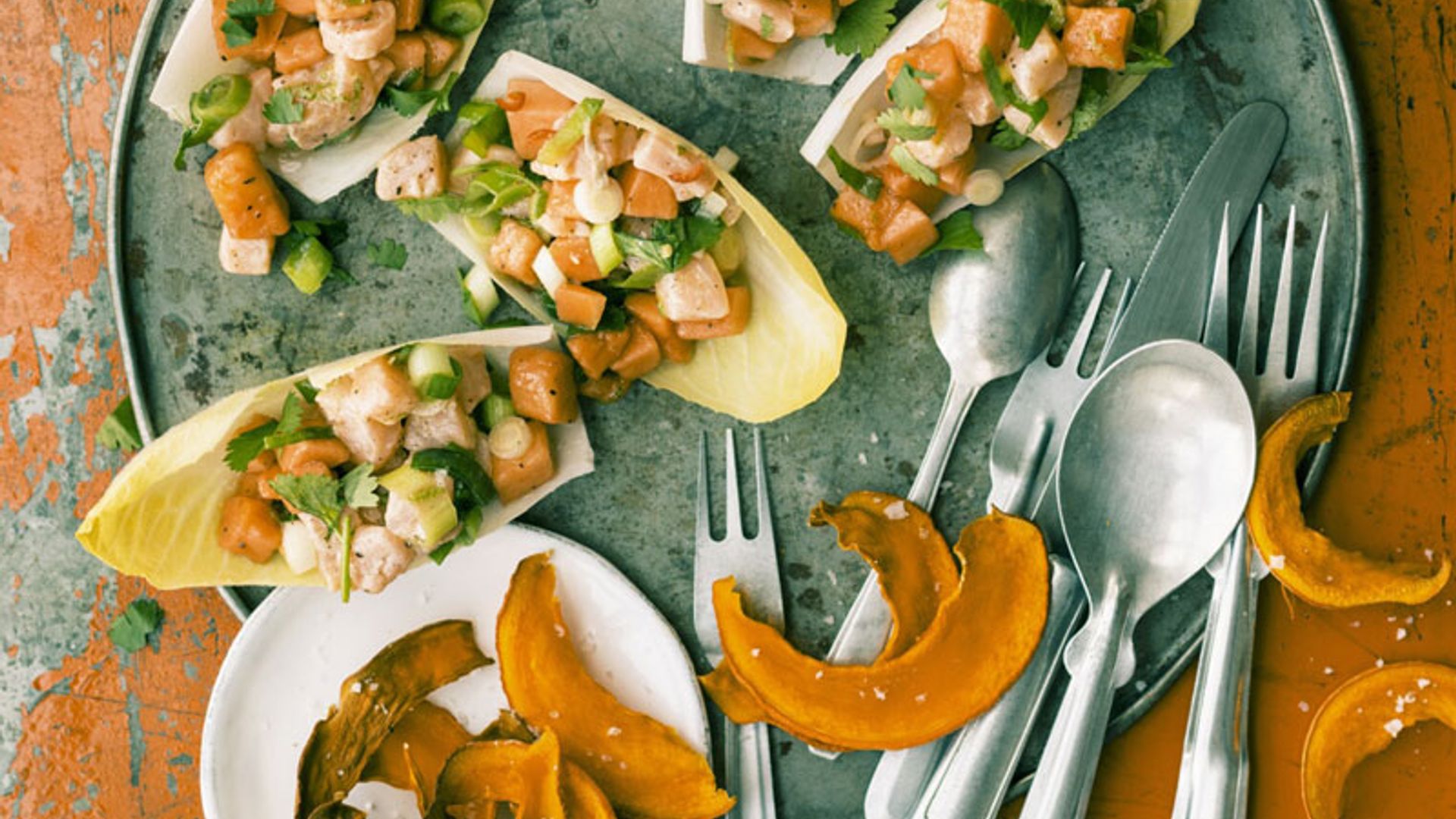 Ceviche de salmón y papaya sobre endivia con chips de calabaza