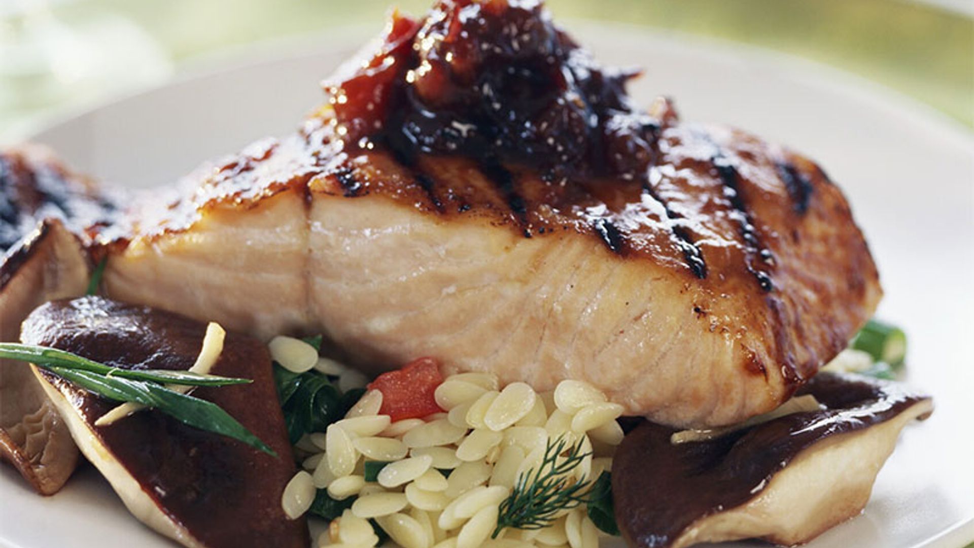 Salmón a la parrilla con salsa de ciruela y jengibre, orzo y setas