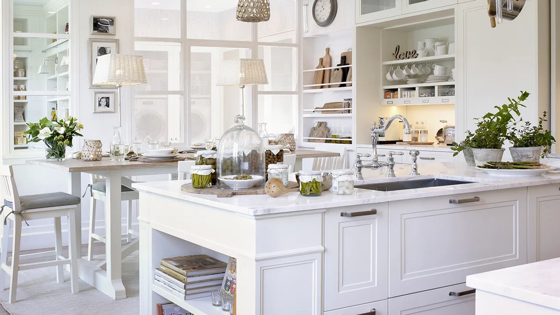 Cocina con comedor y tabiques de cristal en color balcón, con isla de cocina y mesa de comedor alta al lado 