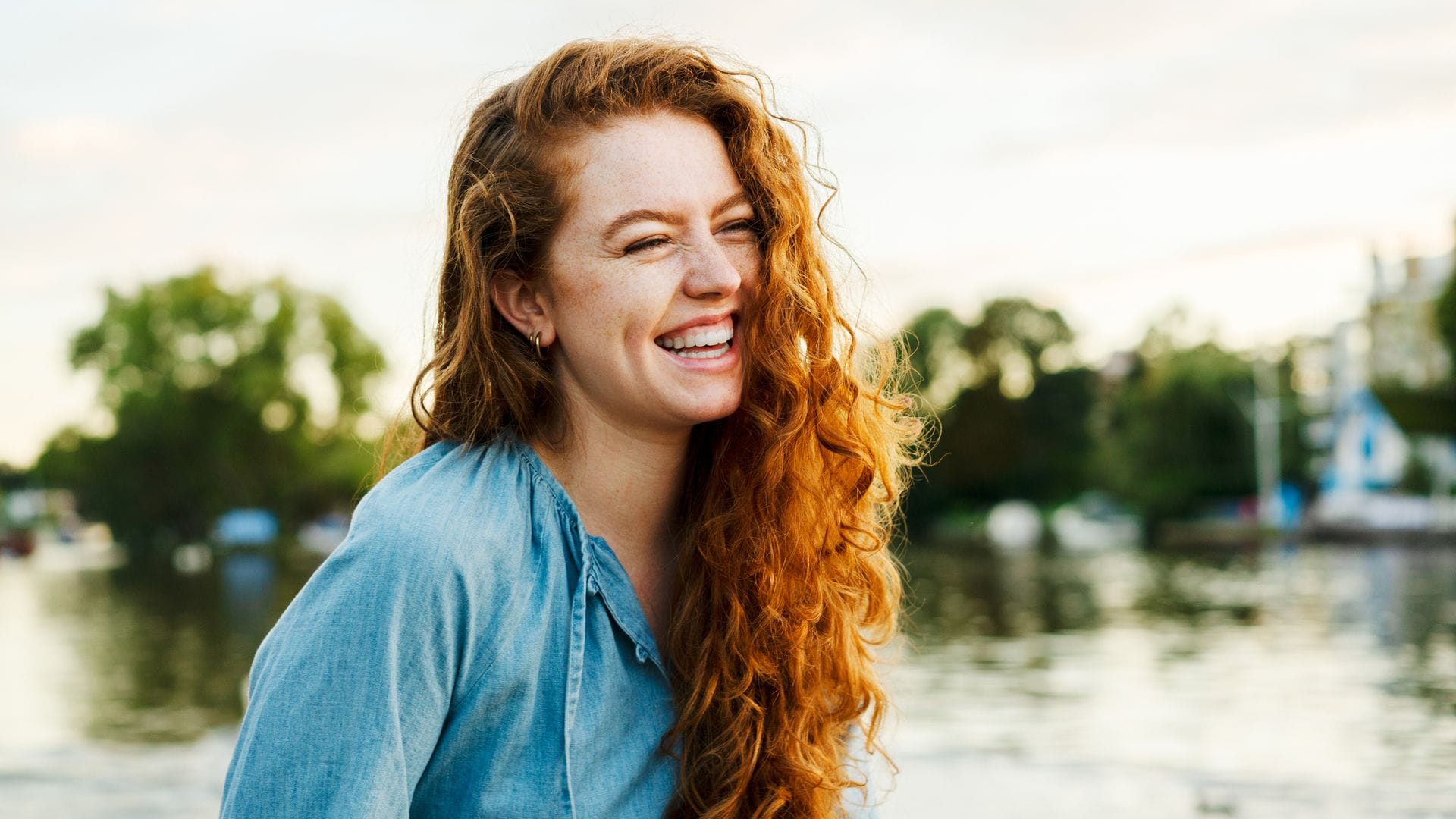 mujer pelirroja riéndose al aire libre