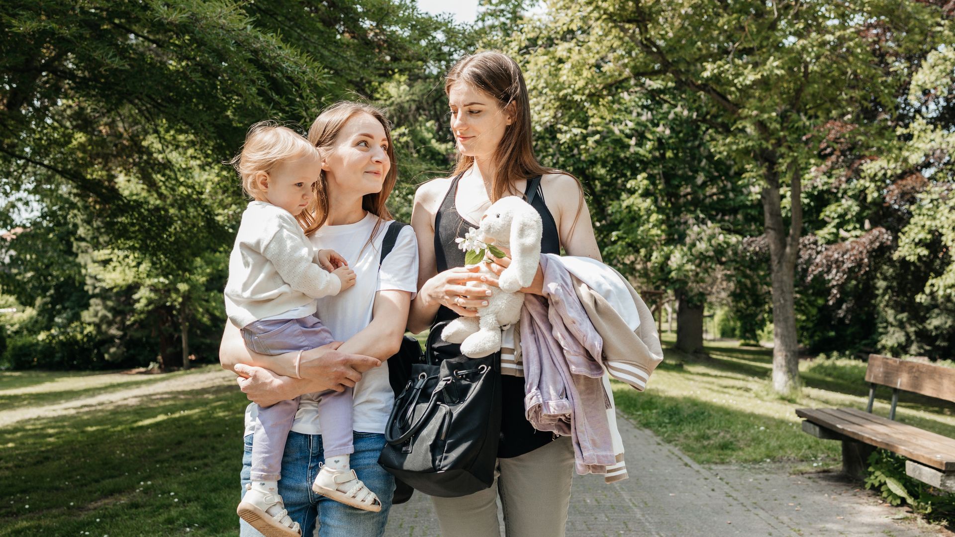 dos amigas paseando con un bebé en brazos