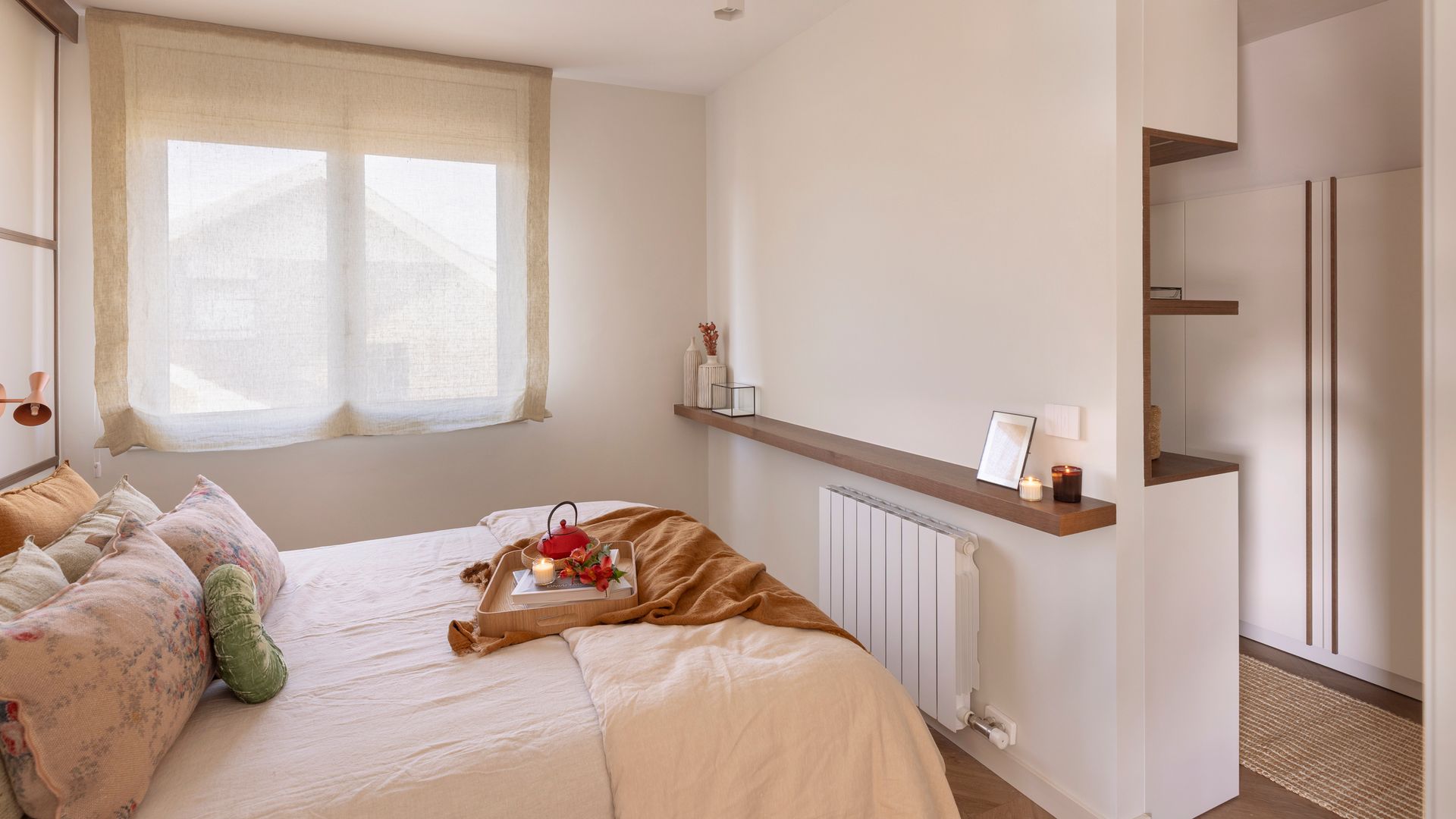 Dormitorio con vestidor, balda sobre el radiador, estor blanco