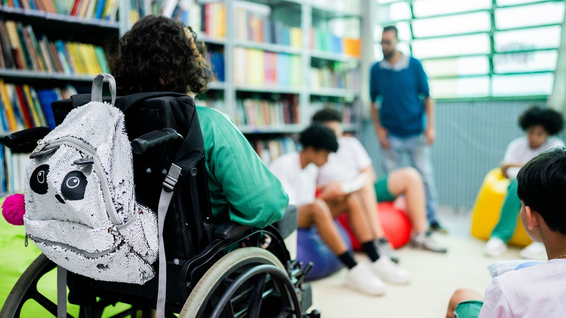Niña en silla de ruedas en la biblioteca del colegio