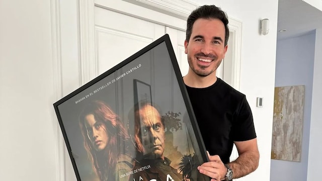 Plano medio de Javier Castillo sosteniendo un poster de la serie basada en su novela